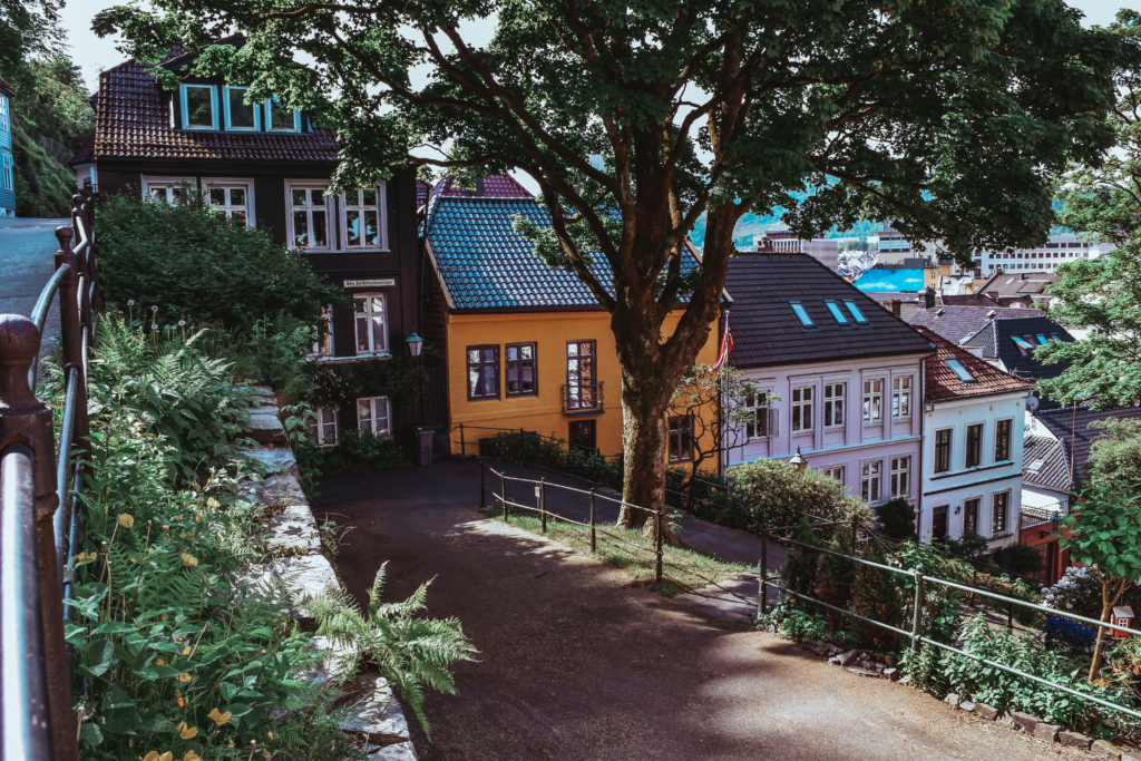 Bergen might be one of the most sought-after cities in Europe for its charm, history, and postcard-perfect setting on the fjord. Here's my guide on how to explore Bergen in 24 hours. PHOTOGRAPHY PROPERTY OF SVADORE As Patrick and I migrated from East to West of Norway in just 4 days, we made it to our final city and the one of the oldest port cities in Europe, Bergen. You can catch more on our journey from Flam to Bergen via a ferry on the stunning Sognefjord in Uncovering the Sognefjord From Flam to Bergen Via Ferry. With 1 day to spare, we decided to see as much as we could of the city. As our ferry pulled into the port 8PM on this sunny May day, we immediately saw the famed colored houses of Bryggen. They reminded me of the houses you would use to play Monopoly all stacked up nicely one next to the other creating a perfect rainbow. Locals and tourists speckled the street in front of the houses, dining in front of them right on the wharf. Bergen is known for its rain. If you think London is rainy, you are wrong. Bergen is considered the rainiest city in the world. It rains 240 days per year! If you want to witness a rare sighting in Bergen, visit the city in late May/early June like Pat and I did. The 2 days we were there we saw nothing but sun (literally both during the night and day due to the sun never truly setting). We dropped our bags off at our Airbnb just a 10 minute walk from the wharf and made our way in search of dinner. More on that in my next post! As soon as we stepped out of our Airbnb we immediately were immersed into Bergen's picture perfect atmosphere. The sun was "setting," as much as it can in Bergen in the summer, creating a pink aura over the cobblestone streets and houses. The next morning as Pat I walked out to grab breakfast and explore the city, we noticed a a graffiti masterpiece a few yards down from our Airbnb. Something you'll notice about Bergen is that although it is famous for it's historical architecture, it is a very alternative city. In fact, it is gaining a new and second reputation as a vivid street art scene. You will see graffiti throughout the city, but not in a vulgar way. Is it a street art that brings satire, recounts history and portrays the artwork of the city. View from our Airbnb balcony The street outside of our Airbnb Without further a due, here's what to see, do and eat in just 24 hours in Bergen: 1. Bryggen We started our journey in UNESCO's Bryggen—or wharf in Norwegian. I like to call this the the postcard motif. It's a mix of bakeries (with amazing pastries!!), hotels, pubs, museums and restaurants. We stopped by one of the bakeries and grabbed some pastries and a cappuccino to get our day started. The pastries at first didn't seem that appetizing to me, but boy oh boy was I wrong. Creamy deliciousness! If there is one thing Norwegian's are good at making—it's pastries!! Finished our breakfast we made our way down the wharf. One thing I love about Norway is how eco-friendly they are about everything, especially water. They try to reuse bottles as much as possible and have stations set up throughout the town were people can refill their water bottles with fresh water so they don't have to waste plastic. Maybe this eco-consciousness is why Norway is such an impeccable country! 2. Øvregaten The street right below our Airbnb and right above Bryggen is Øvregaten. It is considered one of Bergen's main streets and was once the town's main market where cobblers, tailors, artisans and more wood come to trade. Today the road is occupied by antique shops and the occasional tattoo parlor, I mean we are in Bergen after all! 3. Lose Yourself In Bergen's Streets We spent the majority of our morning getting pulled left and right by the adorable streets of Bergen. We originally had a plan, but as we kept walking, every small street was calling our name begging us to explore it. For a look at some of our most favorite streets see below: On our way to grab breakfast 4. Fisketorget Fish Market As it gets closers to lunch time we find ourselves wandering towards the famous Bergen fish market. The market is open every day from the first of May to the end of September. This fish market is again part of the port, fishermen, and trading locations history. It's been an ongoing market since the 1200s and still very much in use today. No need to fear if you come here in the winter, the indoor market located just a few steps from the wharf has the same quality food and is open year round. Fresh caught seafood for sale. Paella with mixed fresh caught seafood offered for lunch. Live caught crabs for sale 5. Skostredet (Art district) Next up, wander around the street of Skostredet, the up and coming street art district in Bergen. Truth be told, you will come across a lot of street are when exploring Bergen, but this area is explicitly dedicated to it not only on it's walls but in it's stores too. 6. Torgallmenningen I recommend you start by walking down Lille Lungegårdsvannet pond and making your way to Marken Street, a quaint cobblestone street with plenty of food options and hidden trinket stores. Then you make your way up to Make your way to Torgallmenningen, or Bergen's Fifth Avenue for an array of activities. Here you can do some shopping, walk by the beautiful Musikkpaviljongen pavillion in Byparken park, sit on the lawn of the newly renovated Art Nouveau theatre, and enjoy lunch at the highly acclaimed Cafe Opera (which is what we did!) Marken Street 7. Klosteret The walk to Klosteret street was one of our favorites. We came across a lot of beautiful old style homes and colorful streets rich in flower pots and immersed in history. Keep walking and you reach the area of Klosteret, Kloster means Monastery in Norwegian. The street is called Klosteret because a famous Monastery used to be here that dates back to 1135. Today it is a beautiful residential area that houses one of our favorite restaurants—Spisekroken! 8. Mount Floyen A trip the top of one of the seven mountains surrounding Bergen, Mount Floyen, is a must when there. We recommend taking the funicular which gets you up there in less than 6 minutes and offers stunning views. An alternate route (and if you have more time) would be to hike up the side of the mountain. That would take roughly 1 hour to get up. From here you can catch breathtaking views of the city, either from the platform balcony they provide or from smaller hidden areas such as the one that Pat and I found below. There is a restaurant at the top where you can enjoy lunch, dinner, snack or a nice cold beer on one of the few sunny days. 9. Tubakuba Many don't know this, but there is more to explore on Mount Floyen than just the view. Roughly 100 yards away from the viewing area hides Tubakuba, a sleekly designed rabbit hole cabin available for anyone to sleep—FREE OF CHARGE. That's right, you heard me. Free. You need to apply to be accepted to sleep in it but you can stay in this quaint rabbit hole with views of the city overlooking Bergen. The only reason Pat and I didn't take it is because we were scared of being so far away from the city, and who knows...bears and coyotes could be roaming this area for all we know. But, if you are not a scaredy cat like me, I would totally jump at the occasion of staying in this architectural masterpiece built by students at the Bergen School of Architecture. A few key things to note before you consider this stay: It does not have electricity, so all heat in the winter is provided by a small wood burning stove and a lot of insulation. I'm not so sure about lights, but I'd assume that isn't something that is available either, you will have to use the light shining through the enormous window in the summer. 10. The Hanseatic Headquarters Bergen is famously known for its history in the Hanseatic League, also called Hansa. It was an organization founded by northern German towns and merchant communities to protect their mutual trading interest. To avoid the crowds of tourist during the day, Pat and I decided to visit in the later afternoon and we recommend you do the same! Since Bergen was one of the first ports in Northern Europe, it seemed fitting to have one of the 4 Hanseatic headquarters set up here. Today, it is the only Hanseatic League headquarters left that is still preserved. Each summer, these German merchants would set up shop in Bergen in the area that we today call Bryggen. It is made up of the wharf and the Hanseatic Headquarters where they once lived. Today it is considered a UNESCO World Heritage Site. In my opinion, the headquarters look identical to Diagon Alley and could have in fact inspired J.K. Rowling. Take a look for yourselves if you don't believe me: The wooden houses that adorn these maze-like and Harry Potter-like streets have caught fire time and time again. The great fire of 1702 turned Bergen to ashes, but rather than rebuild from scratch, the locals kept the original foundation from the 12th century and have rebuilt upon using the old patterns and methods. This is what makes Bryggen such a world marvel! The last fire was in 1955. Because of this effort, today approximately 62 buildings within the Hanseatic Headquarters still remain of this former townscape. The headquarters is set up like it once was with the merchants shops on the ground floor and the merchants homes on the top. As you walk around, you really get a sense of what it was once like back in the day! Pat kissing a moose! 11. Bergunhaus Fortress Welcome to one of the oldest and best preserved fortress' in Norway. It used to house the royal family back in the 13th century. It was a very important fortress back in the day and was even where the first set of laws were drawn up for Norway. Located right at the end of the Bryggen wharf, this fortress is open to the public. We visited later on in the day and unfortunately were not able to see the hall inside. Haakon's hall looks identical to the Great Hall in Harry Potter in my opinion! Another coincidence..? I think not, but that's just my opinion. Google it and let me know if you don't agree. Today the hall is still used for royal dinners and other important events. 12. Happy Hour at Rock & Roll American Diner Now I know what you are thinking. Ugh, typical American stopping by an American diner when abroad instead of immersing herself in the culture. I promise you this is NOT the case with Rock & Roll American Diner. The place is a hot spot in Bergen and filled with locals. They've done a better job at bringing back to life our diners then we have! Imagine eating in an actual car inside the diner (I kid you not, one room is dedicated just to that!), sipping huge milkshakes, a room full of old school jukeboxes and records still playing, vintage tall boys and seats. It's a dream come true and made me feel like I was whisked away back to the 80s. Pat and I stopped here for a quick drink among the locals before heading out to dinner. 13. Dinner at Spisekroken Our night ended with dinner back near Klosteret at Spisekroken. The setting is small and quaint and you wouldn't expect anything to grandiose, but the meal is fit for a Michelin star. Their french-inspired cuisine was out of this world and has Patrick and I still talking about their food to this day. The best duck I have ever had and the best lamb Pat has ever had. More on our dinner in my upcoming posts. Duck from Holte farme served with wild garlic potato carrot pure, baked salsify baked in lemon, honey and wild garlic sauce Gourmet veal from Sogn with parsly and parsley root pure, gooseberry sauce small potatoes, pickled red onions, baked carrot, asparagus and grilled sweet bread. Now I know what you are thinking. Sveva...how on earth did you get that all done in ONE day? I promise you it is possible. The city is small, and you will get distracted continuously by the adorable streets. But if you are out the door by 9AM and out till 10PM, you will manage. As mentioned, the sun never sets in the summer so you have THAT much more time during the day to explore the city and you don't get tired because you're body doesn't understand that it needs to go in night time mode. Bergen is a jewel, no wonder it inspired the setting of Disney's Frozen and in my opinion Harry Potter as well! To uncover its magic and its surrounding nature escapes you definitely will want a few days in the area. But if you are limited in time, follow this guide for a sure fire way to immerse yourself in as much of the city as you can in one day. Get insider travel tips and lifestyle content on the world’s most exceptional destinations, experiences and products directly to your inbox. Don’t miss out–sign up for travel blog SVADORE on the right hand side to stay up-to-date on where to go, what to do, what to see, where to stay, and where to eat around the globe. Follow Svadore on Instagram: @SVADOREand @SVADORE_eats Follow Svadore on Twitter: @SvadoreTravels Follow Svadore on Pinterest: SVADORE Follow Svadore on Facebook: SVADORE