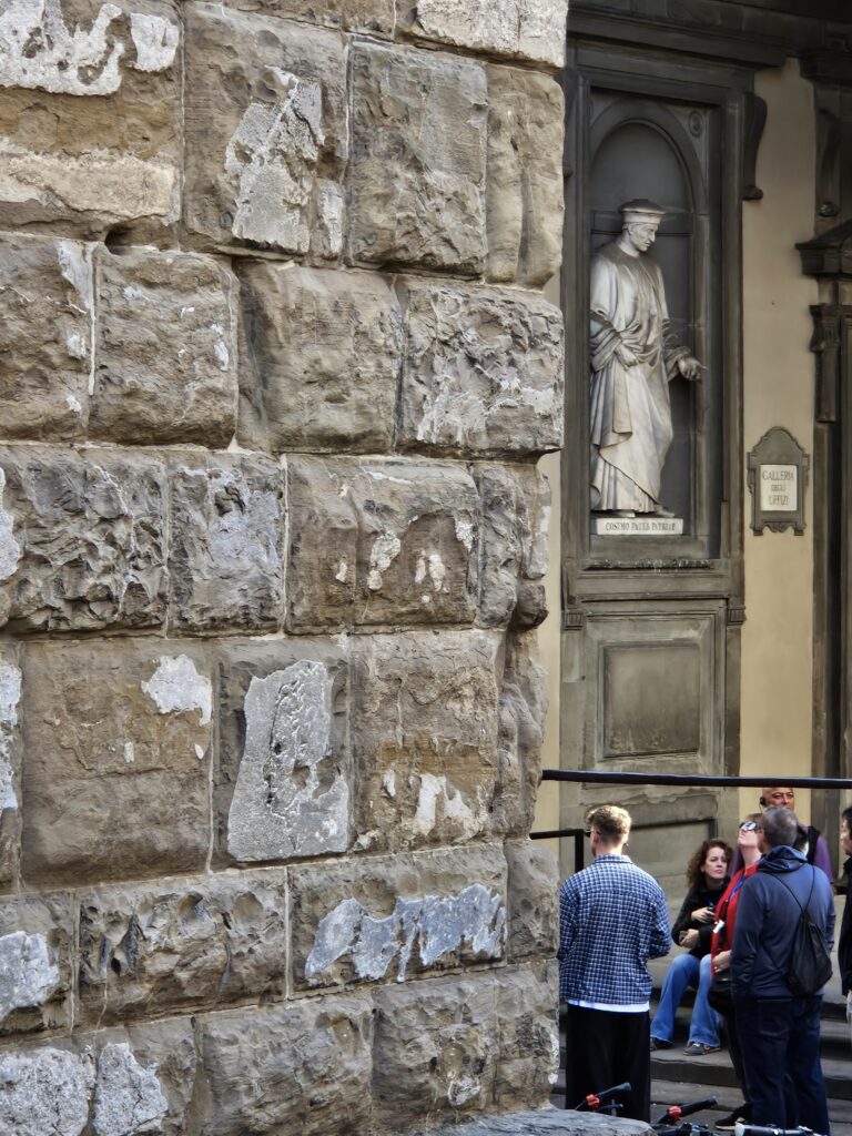 The "L'Importuno" profile carving by Michelangelo on the wall of Palazzo Vecchio.