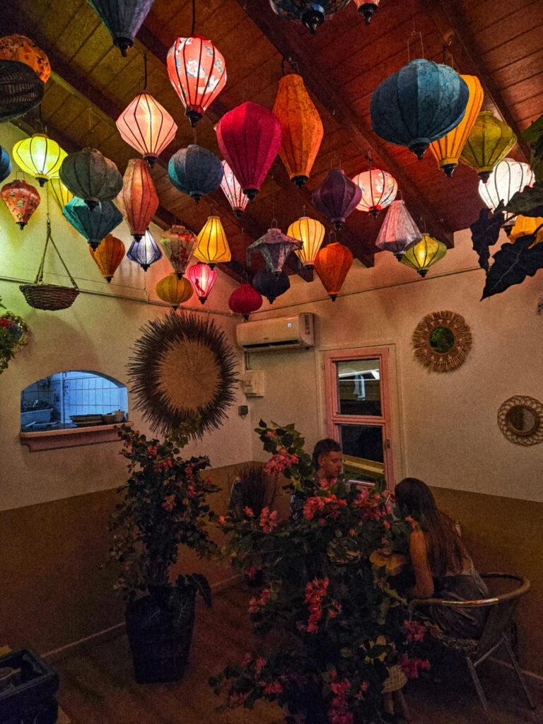 Bohemian interior of Nyama in Corossol featuring colorful Asian lanterns and greenery